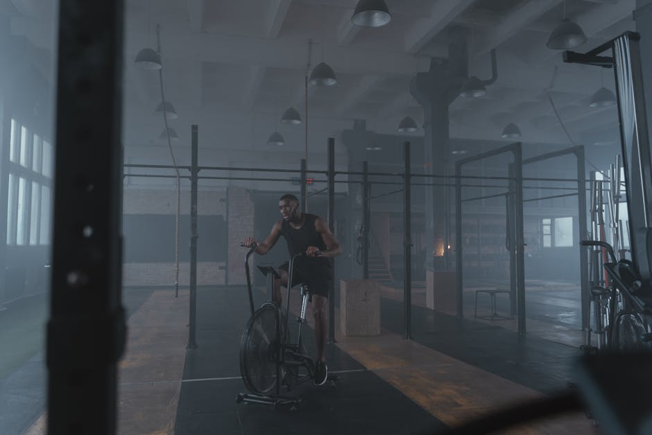 Focused athlete exercising in an industrial-style gym on a stationary bike