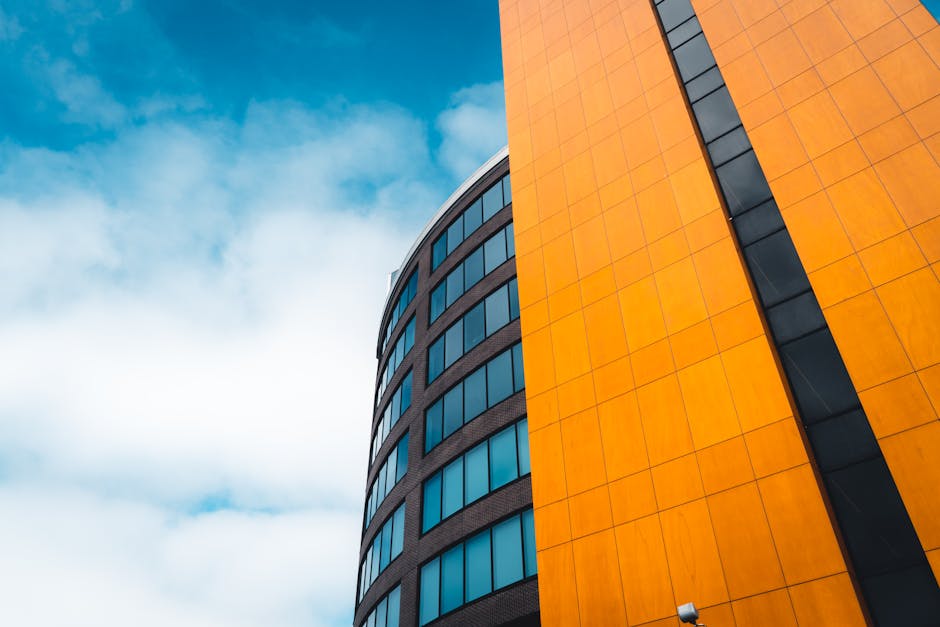 Contemporary office building with striking orange facade against a blue sky