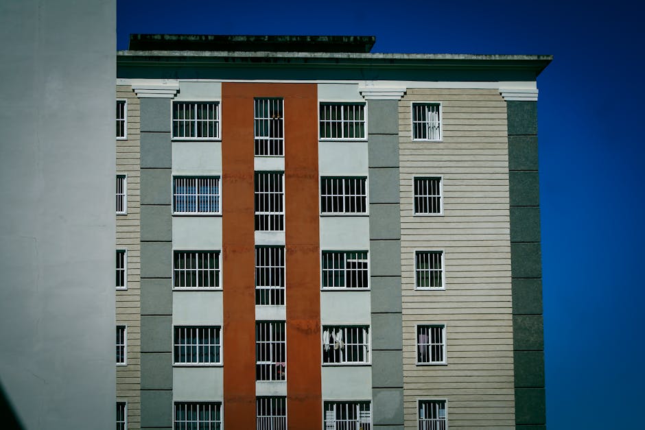 Facade of a modern high-rise building with colorful design against a clear blue sky